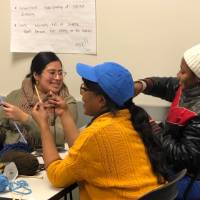 staff and students learning knitting in DEV